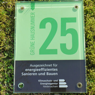 Auszeichnung Gr&uuml;ne Hausnummer vor Moos